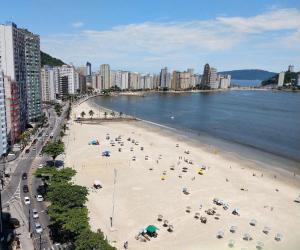 una playa con mucha gente y sombrillas en Flat São Vicente 5 minutos da praia, en São Vicente