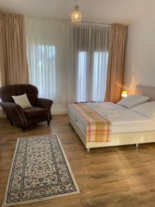 a bedroom with a bed and a chair at Pension zum Landhaus in Drewitz