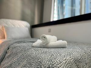 a stack of towels sitting on top of a bed at Partition Room With Window Near MOE Metro in Dubai