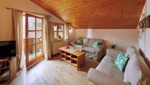 a living room with a couch and a table at Hochgallinger Hof - Der Reiterhof für Groß und Klein in Siegsdorf
