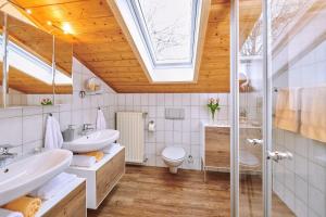 a bathroom with two sinks and a toilet and a skylight at Hochgallinger Hof - Der Reiterhof für Groß und Klein in Siegsdorf +26 photos