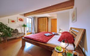 a bedroom with a large bed with a red blanket at Hochgallinger Hof - Der Reiterhof für Groß und Klein in Siegsdorf