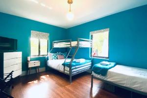 een blauwe slaapkamer met 2 stapelbedden en een raam bij Lush Tropical Villa - 3 2 with Pool and Renovated in Miami