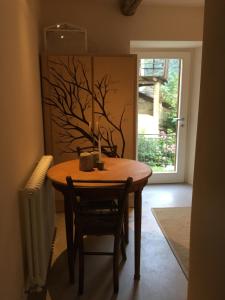 a dining room table with a tree painting on the wall at B&B Valle Spluga Il Pertugio in Chiavenna