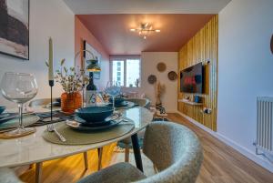 a dining room with a table and chairs at 2 Bed Chic City Apartment, Spacious, Sleeps 6, with onsite Parking- Near Gunwharf Quays & Beach - By Blue Puffin Stays in Portsmouth