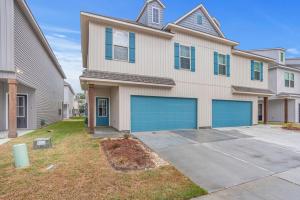 una casa grande con puertas azules de garaje en un patio en Chic Townhouse by LSU en Baton Rouge