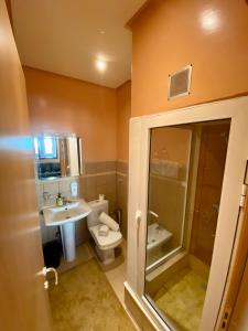 a bathroom with a toilet and a sink and a shower at Appart Hôtel Oleandro in Casablanca