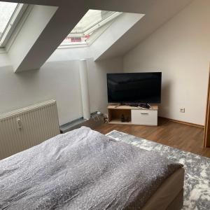 a bedroom with a bed and a flat screen tv at 1 Zimmer Apartment DG in Eislingen