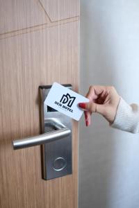 a person holding a do not disturb sign on a door at Dem Premium Hotel - Round Trip Airport Service - Istanbul International Airport in Arnavutköy