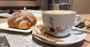 a cup of coffee and a pastry on a table at Beatrice Room Bed&Breakfast in Sant'Agnello