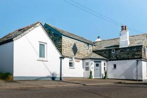 ein weißes Haus mit grauem Dach in der Unterkunft Sandown, St Teath 3 bed sleeps 6 in Saint Teath