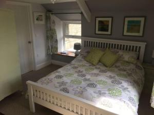 ein Schlafzimmer mit einem großen Bett mit einer Blumenbettdecke in der Unterkunft Sandown, St Teath 3 bed sleeps 6 in Saint Teath