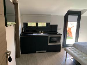 a living room with a microwave and a couch at Hostal el Rocio in Paracuellos de Jarama