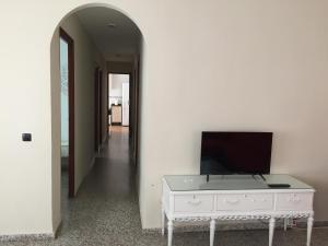 a room with a tv on a dresser and a hallway at El Chalet de Lola in Playa de Miramar