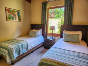 a bedroom with two beds and a window at San Lameer 2604 by Top Destinations Rentals in Southbroom