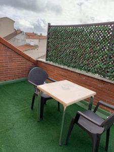 パラクエジョス・デ・ハラマにあるHostal el Rocioの屋根にテーブルと椅子2脚