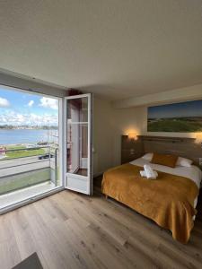 a bedroom with a large bed and a large window at Couett'Hôtel Brest in Brest