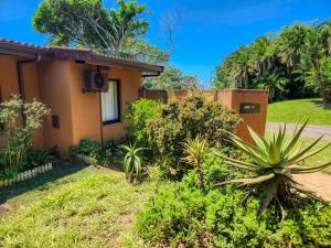 a house with a garden in front of it at San Lameer 2604 by Top Destinations Rentals in Southbroom +27 photos