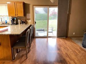 a kitchen with a counter with chairs and a table at 7Pines Retreat in Omaha