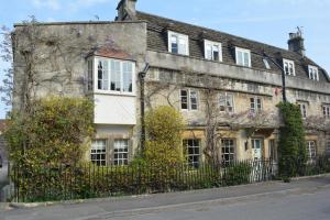 an old stone building with a fence in front of it at Wee Grange in Bath