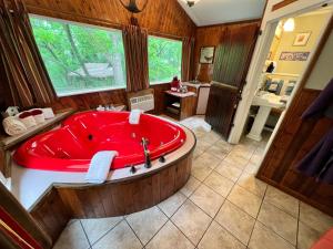 a large bathroom with a red tub in it at Sherwood Court Cottages in Eureka Springs