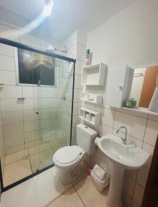 a bathroom with a toilet and a shower and a sink at Apartamento ACOMODA 5 PESSOAS próximo ao Uberlândia Shopping in Uberlândia