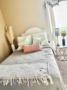 sypialnia z białym łóżkiem z poduszkami i oknem w obiekcie My Little Southern Comfort w mieście Thomasville