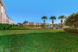 a park with palm trees and a building and a body of water at Atlantis Bliss Haven in Saint Augustine Beach