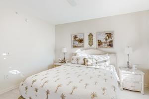a white bedroom with a white bed with a pineapple bedspread at Atlantis Bliss Haven in Saint Augustine Beach