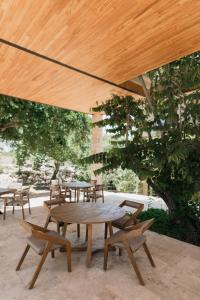 een picknicktafel en stoelen onder een houten parasol bij PiedraViva Tepoztlán in Tepoztlán