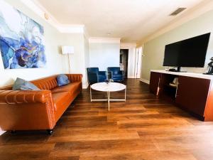 a living room with a couch and a flat screen tv at Bayfront Inn in St. Augustine