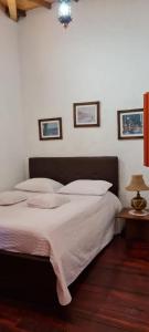 a bedroom with a large bed with white pillows at Casa Patrimonial Abejorral - CASA GASAMA in Abejorral
