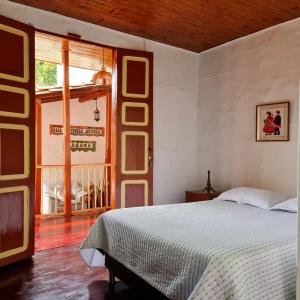 a bedroom with a bed and a large window at Casa Patrimonial Abejorral - CASA GASAMA in Abejorral