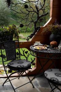 patio con mesa, 2 sillas y ventana en Садиба "Маланка", en Mykulychyn