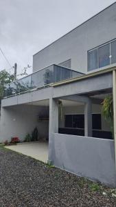 una casa gris con balcón en la parte superior en Linda Casa Piscina Natureza, en Florianópolis
