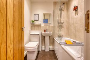 a bathroom with a toilet and a sink and a tub at 2 Bed Chic City Apartment, Spacious, Sleeps 6, with onsite Parking- Near Gunwharf Quays & Beach - By Blue Puffin Stays in Portsmouth