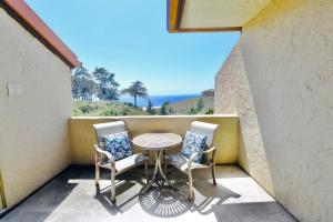 a small balcony with a table and two chairs at Premium Villa - Ocean View - SEASCAPE - Heated Pools - Relaxing Fireplace - Ground Level in Aptos