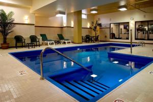 a large swimming pool with blue water in a hotel at Fairfield Inn & Suites by Marriott Montreal Airport in Dorval