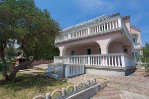 a large house with a balcony and stairs in front of it at Krk Kornic Apartments in Kornić