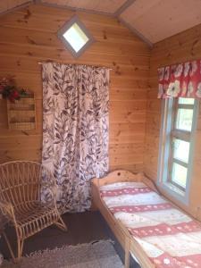 a room with a bed and a window in a log cabin at Tunnelmallinen talo Haukiputaalla. in Oulu