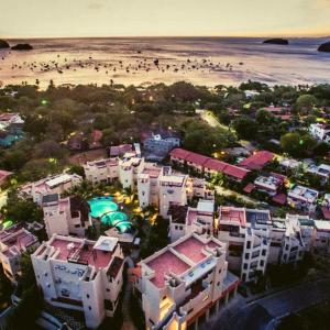 una vista aérea de una playa con edificios y personas en Tropical Gardens Suites and Apartments, en Coco
