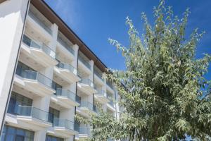 an apartment building with a tree in front of it at Nautic Luxury Club in Mamaia Sat/Năvodari
