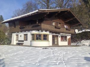 a house with snow in front of it at Chalet Horn by Apartment Managers in Kitzbühel
