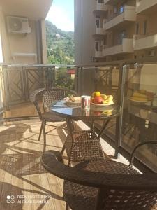 a table with a bowl of fruit on a balcony at A cozy apartment near the sea in Kvariati