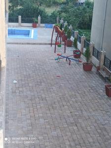 a patio with a pool and some chairs and plants at A cozy apartment near the sea in Kvariati