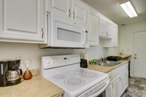 a white kitchen with a stove and a sink at Quaint Orangeburg Townhome Near Hospitals and Campus in Orangeburg