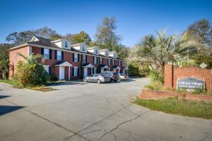 a large brick house with cars parked in a driveway at Quaint Orangeburg Townhome Near Hospitals and Campus in Orangeburg