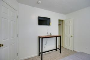 um quarto com uma mesa e uma televisão na parede em Quaint Orangeburg Townhome Near Hospitals and Campus em Orangeburg