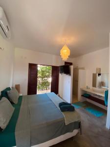 a bedroom with a large bed and a refrigerator at BEACH VILLA Camurupim in Guajiru +87 photos