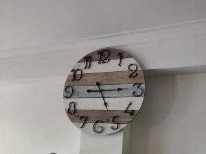 Eine Uhr, die von einer Decke hängt, mit Zahlen drauf. in der Unterkunft Le Raisonnable in Porto